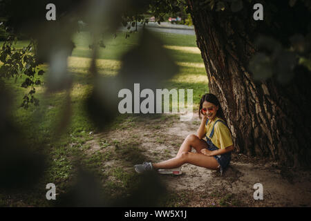 Femme assise sous un arbre dans le parc, Serbie Banque D'Images