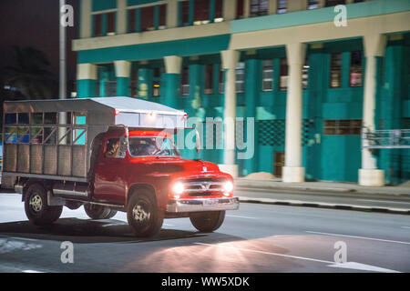 Camion rouge avec des phares dans l'avant du bâtiment de couleur turquoise à La Havane, Cuba Banque D'Images