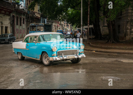 Bleu-blanc vintage car tournant autour d'un coin de rue à La Havane, Cuba Banque D'Images