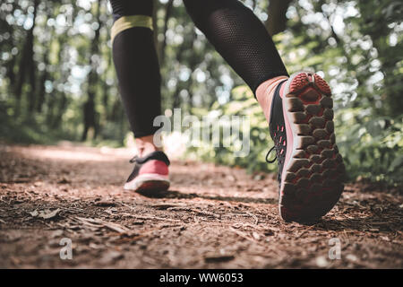 Libre d'une fille sportive se prépare à exécuter dans la forêt. Jeune athlète femme pour commencer à courir. Cropped shot of a woman's legs sortir courir Banque D'Images