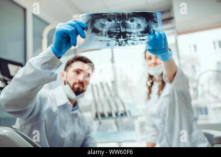 Dentiste et son assistant s'agit de dossier du patient. Focus sélectif. Banque D'Images