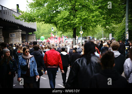 Les passants, manifestants et badauds marchant le long de l'underground rails dans Kreuzberg, pendant la manifestation du 1er mai à Berlin. Banque D'Images