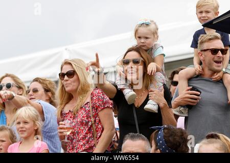 Automne Phillips, à gauche, sa fille Isla sur les épaules de Natalie Pinkham, la présentatrice de télévision de la F1, regardant le Shetland Pony Grand National. Banque D'Images