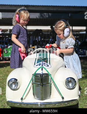 Coquelicot, six (à gauche), et sa soeur Milly, trois, à partir de la Loire, le polonais les Austin J40 Voiture à pédale en avant de samedi, au cours de la Coupe du jour Settrington un des Goodwood Revival au Goodwood Motor Circuit, dans la région de Chichester. Banque D'Images