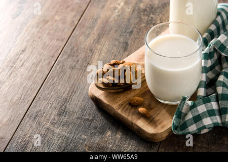 Le lait d'amande en verre et la bouteille sur la table en bois. Copy space Banque D'Images
