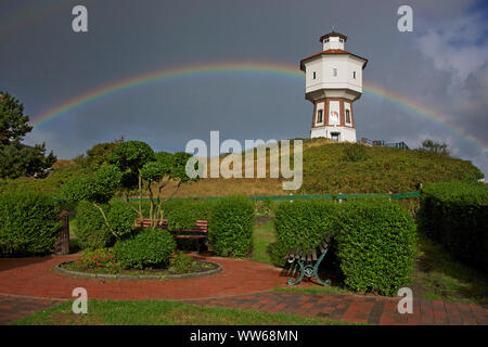 Vue depuis un petit parc sur un arc-en-ciel derrière le vieux château d'eau, le point de repère de l'île Langeoog. Banque D'Images