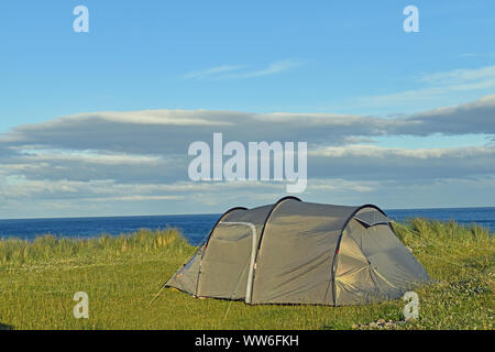 Tente sur l'herbe à l'autre avec vue sur la mer visible en arrière-plan, camping sauvage Banque D'Images