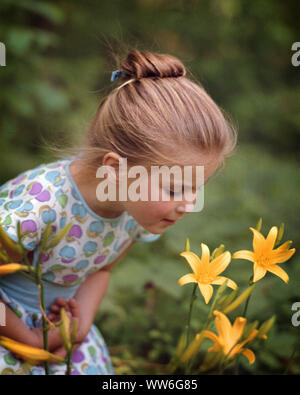 1960 JOLIE PETITE FILLE JAUNE ODEUR FLEXION LIS DU JOUR - kj3407 FTZ001 FLEXION HARS BONHEUR jolie fleur fleurs sauvages LOISIRS AVENTURE JARDINS CURIEUX LILY IMAGINATION fleurs élégantes de l'origine ethnique caucasienne mineurs innocents curiosité old fashioned Banque D'Images