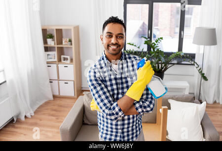 Smiling indian man avec du détergent, le nettoyage à la maison Banque D'Images