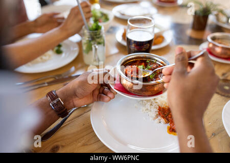 Homme africain de manger avec des amis au restaurant Banque D'Images