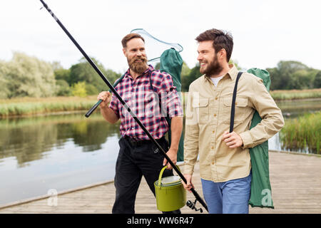 Les amis masculins avec net et des cannes à pêche sur le lac Banque D'Images