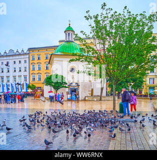 Cracovie, Pologne - juin, 13, 2018 : Le peuple paissez le troupeau de pigeons sur la place du marché, le 13 juin à Cracovie Banque D'Images