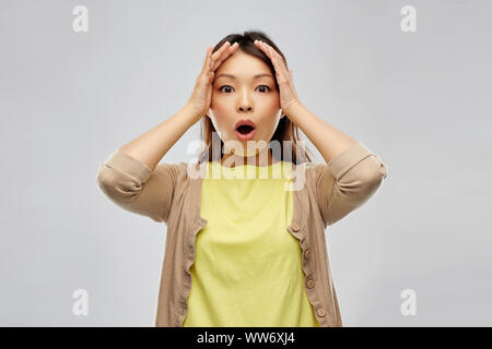 Choqué asian woman holding à la tête Banque D'Images