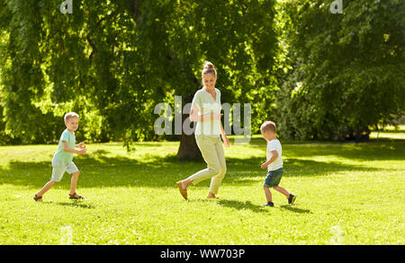 Mère avec fils jouer au jeu capture parc d'été Banque D'Images