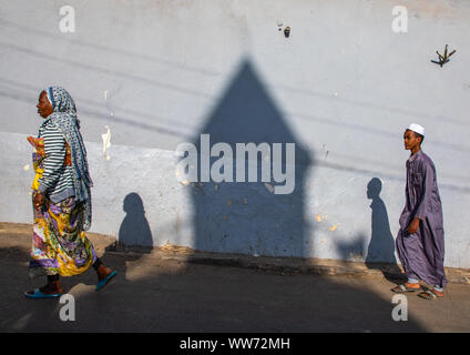 Les gens de l'Éthiopie en passant en face de l'ombre d'un minaret mosquée dans la rue, Harari région, Harar, Ethiopie Banque D'Images