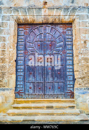 Un arabe typique porte de bois de la mosquée avec la forme d'arc en fer à cheval. Banque D'Images