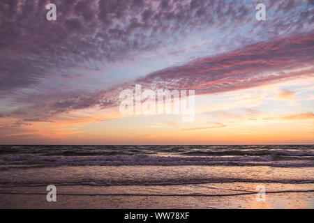 Ciel coloré de coucher de soleil au-dessus des vagues douces le long du rivage à Honeymoon Island, Floride. Banque D'Images
