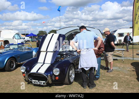 Les visiteurs lors d'un événement à la recherche lors d'une AC Cobra Kit Car anglo-américaine et d'autres véhicules sur l'affichage à Kent, Royaume-Uni. L'été 2019. Banque D'Images