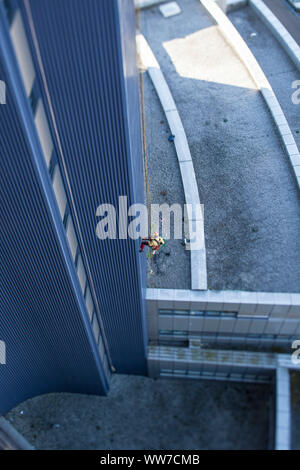 Grimpeur escalade la façade de la tour de chirurgie clinique d'Innsbruck, Tyrol, Autriche Banque D'Images