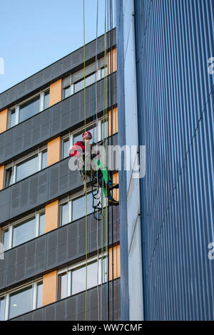 Grimpeur escalade la façade de la tour de chirurgie clinique d'Innsbruck, Tyrol, Autriche Banque D'Images