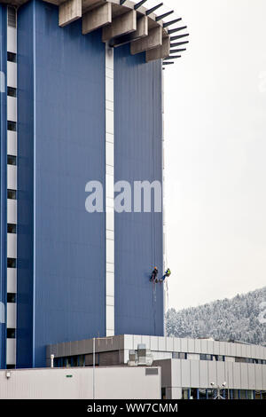 Grimpeur escalade la façade de la tour de chirurgie clinique d'Innsbruck, Tyrol, Autriche Banque D'Images