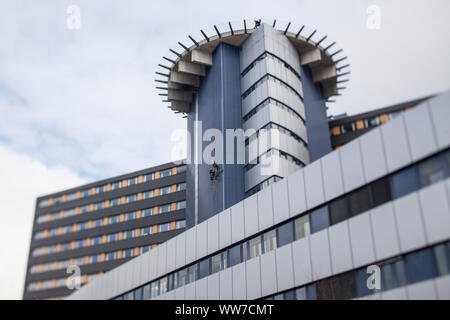 Grimpeur escalade la façade de la tour de chirurgie clinique d'Innsbruck, Tyrol, Autriche Banque D'Images