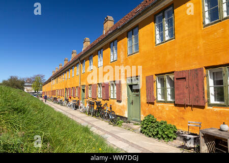 Maisons en rangée historique quartier Nyboder jaune à Copenhague, un ancien quartier de la marine avec des vélos devant les maisons Banque D'Images