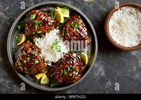 Sucré et épicé grillé au miel cuisses de poulet avec riz sur pierre sombre arrière-plan. Une cuisine savoureuse dans un style asiatique. Haut de la vue, télévision lay Banque D'Images