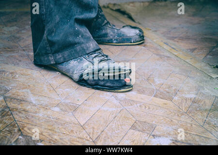 Vieilles bottes déchirées sur les pieds de l'homme. Bottes avec des trous. Selective focus Banque D'Images