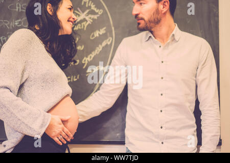 Couple de l'homme et de la femme caucasian heureux les gens heureux et s'amuser avec le ventre de la dame enceinte. sourire et rire en attendant le nouveau fils . amour workds, pas de marques, sur l'étiquette noire en arrière-plan Banque D'Images