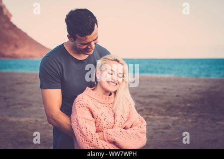 Belle caucasian couple in love hugging et profiter de la plage et l'océan dans l'activité de loisirs de vacances. la tendresse et le bonheur des gens joyeux dans l'air extérieur style de couleurs et filtre vintage. Banque D'Images