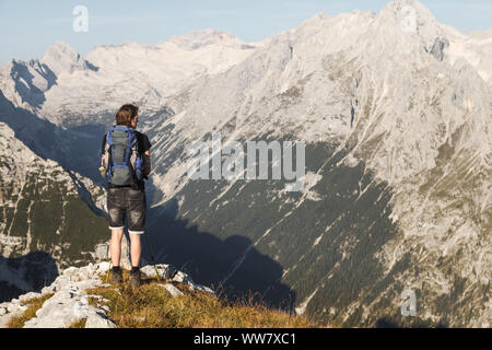 Un jeune homme sur une montagne de la randonnée dans les montagnes de Wetterstein, profitant de la vue sur la Zugspitze et les montagnes à Garmisch-Partenkirchen, Bavière, Allemagne, Banque D'Images