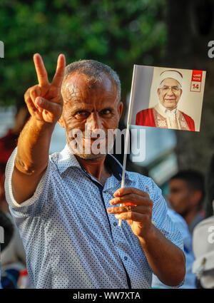 Tunis, Tunisie. 13 Sep, 2019. Un partisan de Abdelfattah Mourou, Vice-président du parti islamiste Ennahda et candidat pour les élections présidentielles à venir, tient l'affiche de la campagne électorale au cours d'un événement de campagne dans la Rue Habib Bourguiba. Le premier tour des élections présidentielles aura lieu le 15 septembre 2019. Credit : Khaled Nasraoui/dpa/Alamy Live News Banque D'Images