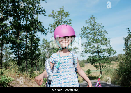 Portrait d'une jeune fille à vélo dans la campagne avec un casque sur Banque D'Images