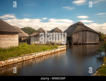 Groupe de plusieurs hangars à bateaux sur chaume Hickling Broad, Norfolk Banque D'Images