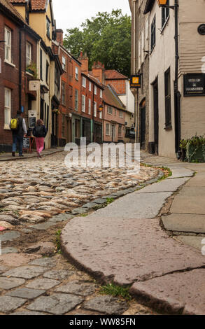 Low angle view jusqu'Elm Hill, à Norwich qui est une très jolie rue de cobble stones et Tudor boutiques et maisons. Banque D'Images