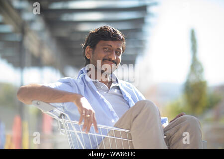 Young man sitting in shopping venture Banque D'Images