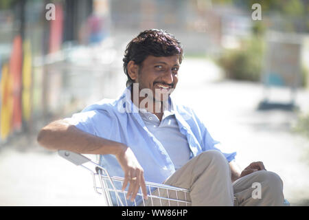 Young man sitting in shopping venture Banque D'Images