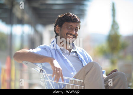 Young man sitting in shopping venture Banque D'Images