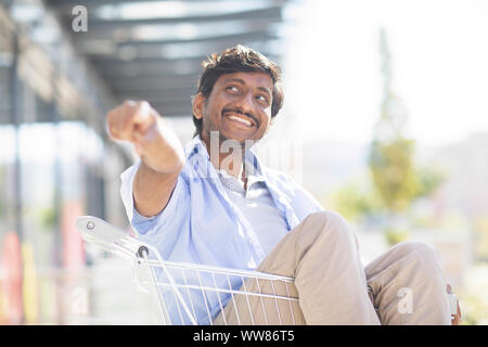 Young man sitting in a shopping venture Banque D'Images