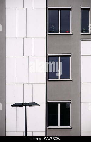 Une lanterne devant une façade de maison moderne avec revêtement mural gris et blanc Banque D'Images