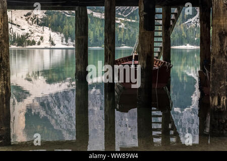 Randonnée d'automne autour de la Pragser Wildsee dans les Dolomites, en Italie. Bateau à rames par la pile d'un hangar à bateaux, logement. Banque D'Images