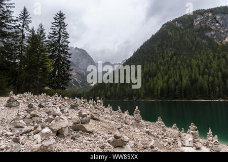 Randonnée d'automne autour de la Pragser Wildsee dans les Dolomites, l'Italie, de nombreux cairns sur la rive, un temps pluvieux Banque D'Images