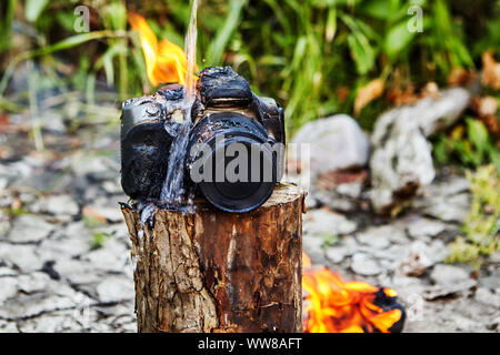 La fin de l'extinction de la flamme les touristes sur l'appareil photo, qui a détruit le feu pendant un incendie de forêt. L'appareil photo reflex numérique a éclaté lorsqu'il a fondu et bur Banque D'Images