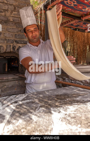 Pide turc pide cuisson Baker pour les touristes à une cuisine de plein air à la plage, près de Bodrum, Riviera turque, la Turquie, l'Eurasie, Banque D'Images