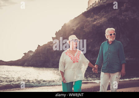 Happy senior couple in love waing souriant et profiter de l'heure d'été sur la plage et la vie à la retraite de leur nouvelle vie ensemble après des années de travail. une place pittoresque avec l'océan et la côte Banque D'Images