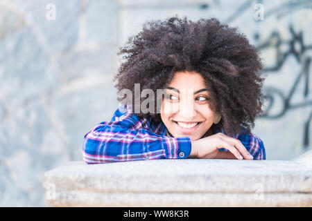 Portrait de race africaine de la peau noire de belle jeune fille souriant et à la recherche à ses côtés. Profitant de l'heure et l'activité de loisirs et de la mode décontractée. avec de longs cheveux afro. beau modèle de course Banque D'Images