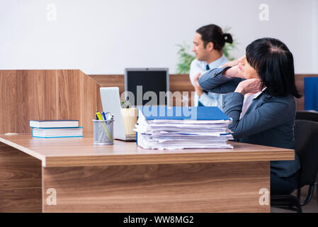 Les deux employés qui font des exercices de sport au bureau Banque D'Images
