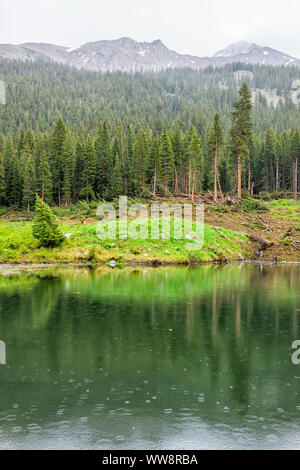 Vue verticale de la pluie tombant sur Conundrum Creek Trail à Aspen, Colorado en 2019 l'été sur petit lac avec réflexion et de gouttes d'eau Banque D'Images