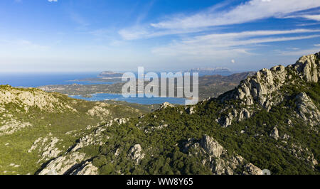 Vue de dessus, vue panoramique de quelques superbes montagnes de granit éclairé par le coucher du soleil. Magnifique baie avec mer turquoise en arrière-plan. Banque D'Images